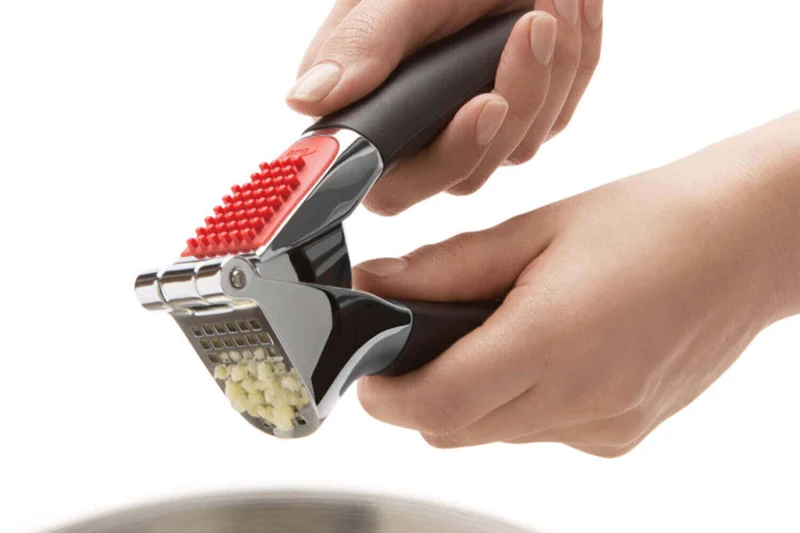 Presse-ail OXO avec brosse à picots intégrée